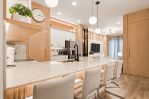 A modern kitchen with a central island, white cabinetry, and a large window. - 5BR Villa Near Disney, Universal & SeaWorld! (Orlando)