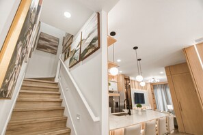 Een moderne keuken met een centraal eiland, roestvrijstalen apparatuur en hanglampen.