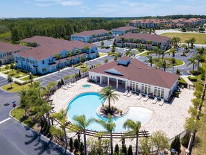 A residential complex with multiple apartment buildings, a swimming pool, and a landscaped area. - Disney Area 3BR Townhome + Resort Amenities (Kissimmee)