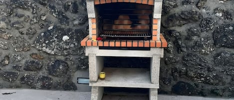 A stone wall with a brick oven structure.