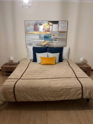 A bedroom with a bed, two nightstands, a lamp, and a large abstract painting on the wall. - Holiday Home 'Quinta De Fonte Coberta' with Mountain View, Wi-Fi and Air Conditioning (Lavradas)