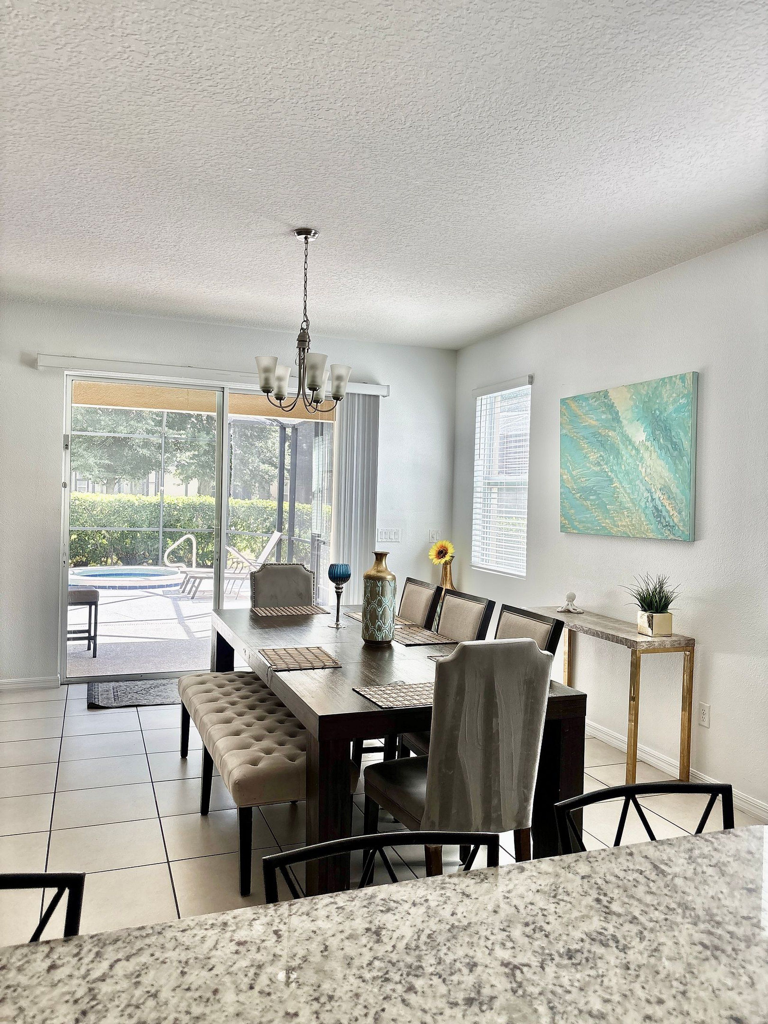A dining area with a table, chairs, and a chandelier.