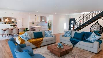 A modern living room with two sofas, a coffee table, and a dining area with chairs and a table.