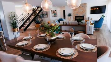 A dining area with a long table set for six, surrounded by modern chairs.