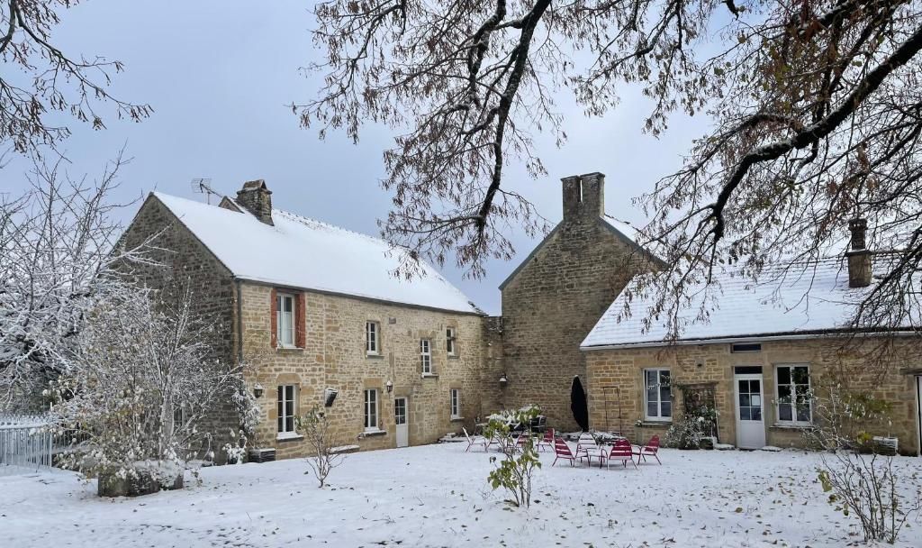 A stone building with a snow-covered roof and a courtyard with outdoor seating.