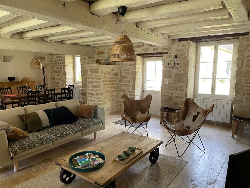 A rustic interior with a sofa, dining table, and chairs.