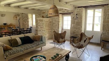 A rustic interior with a sofa, dining table, and chairs.
