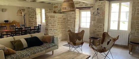 Un interior rústico con un sofá, una mesa de comedor y sillas.