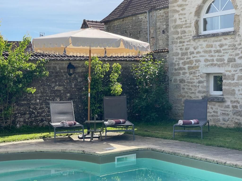 A pool area with lounge chairs and a covered seating area.