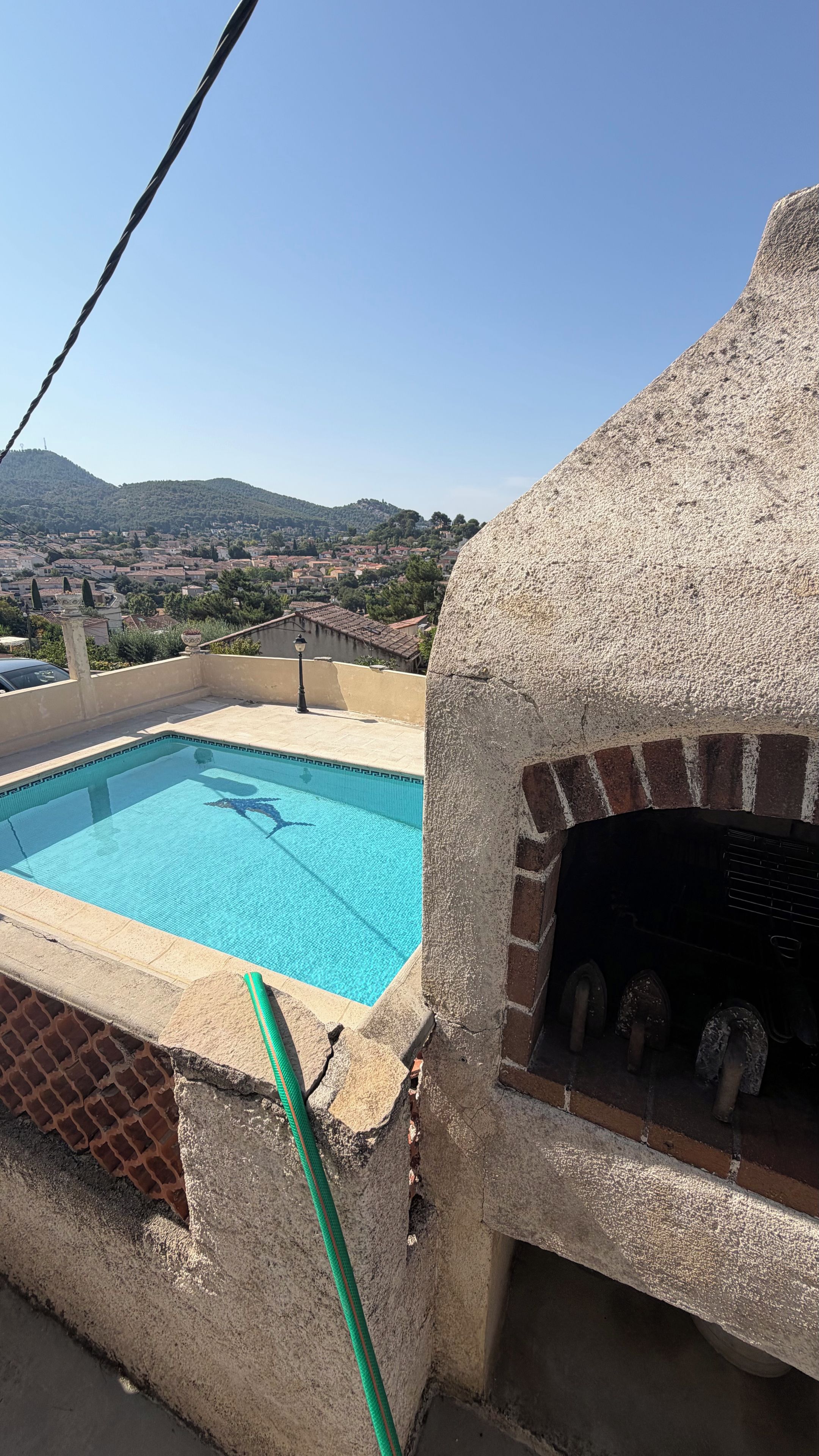 Une terrasse sur le toit avec une piscine et un four à briques.