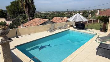 A rectangular swimming pool with a clear blue water surface, surrounded by a tiled deck.