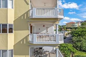 A multi-story building with balconies, outdoor seating, and a view of the surrounding neighborhood. - Blue Bay Ocean View | Luxury 2-Bedroom with Beach Access (Willemstad)
