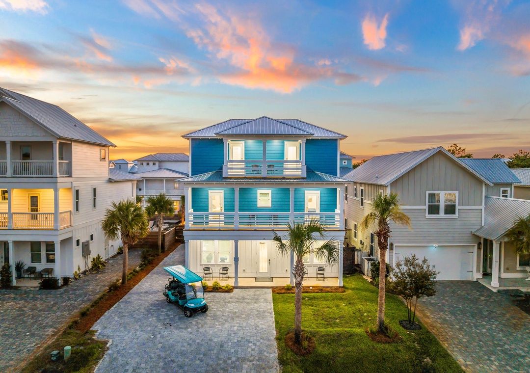 Une maison à deux étages avec un balcon, un garage et une allée.