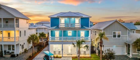 Une maison à deux étages avec un balcon, un garage et une allée.