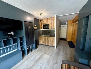 A compact kitchen with a built-in oven, a microwave, and a sink. There is a flat-screen TV mounted on the wall above the kitchen counter. - Studio mountain view - 4 guests (Tignes)