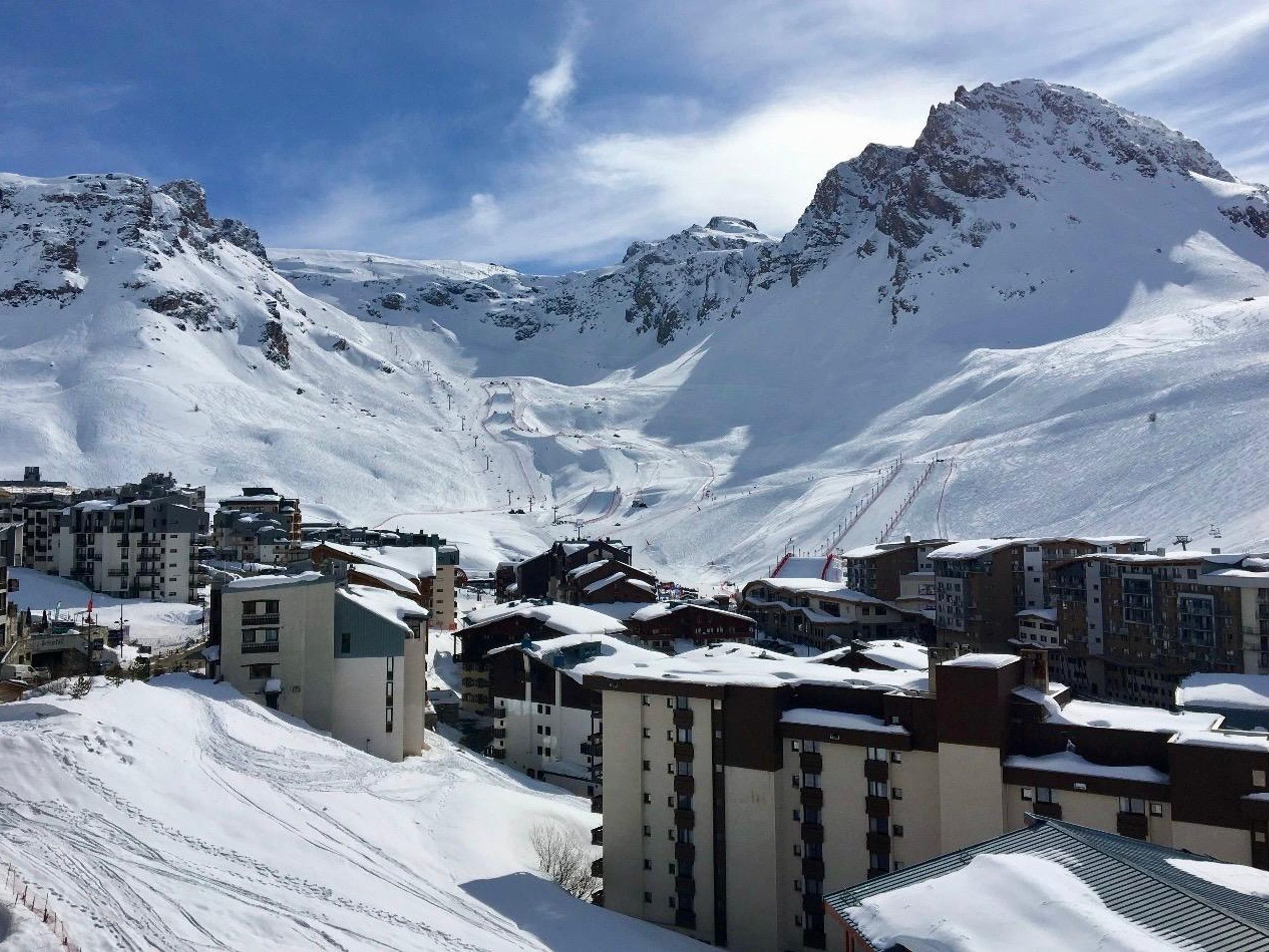 A snow-covered mountain town with buildings and ski slopes.