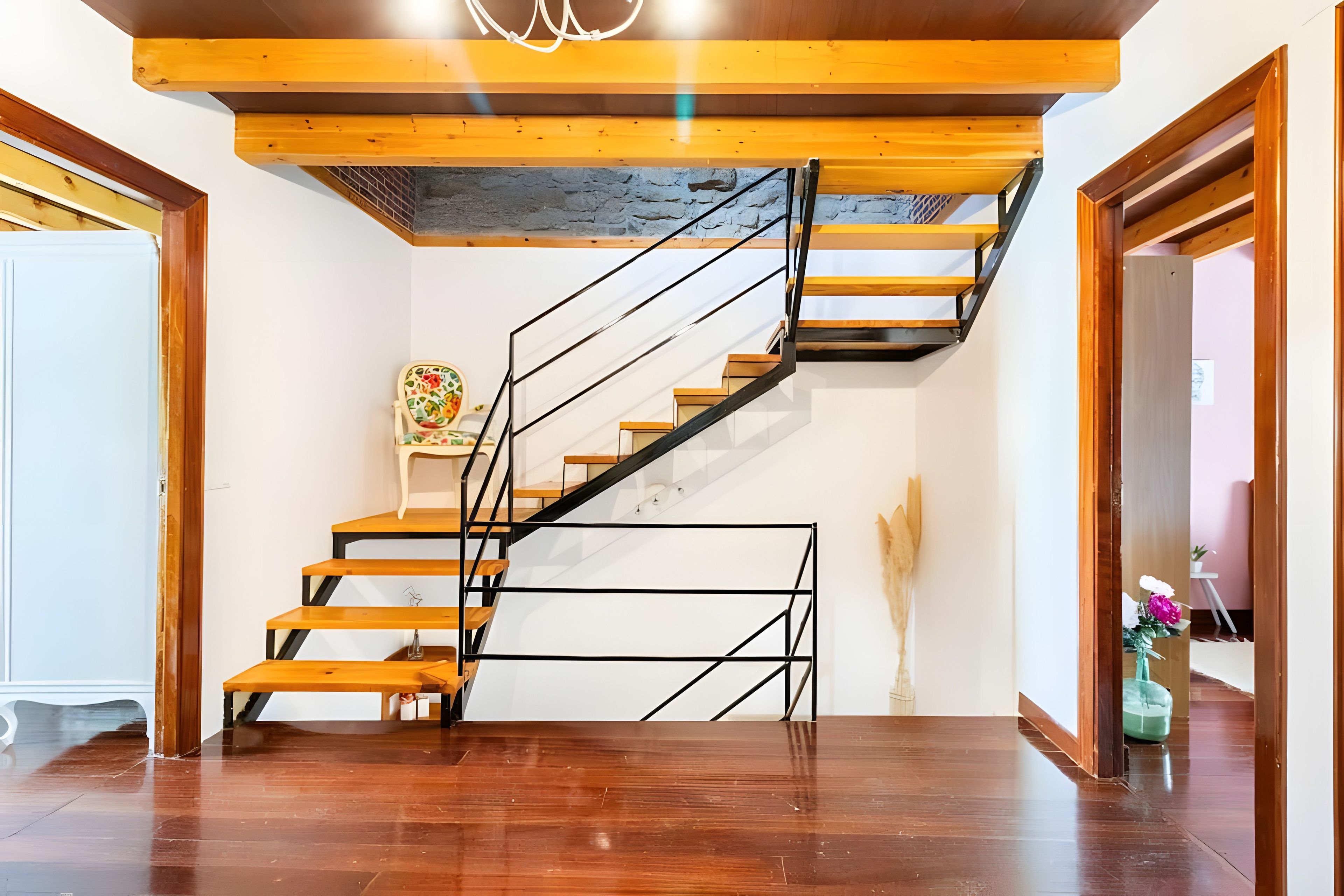 Eine Treppe mit hölzernen Stufen und schwarzen Metallgeländern.
