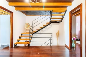 Eine Treppe mit hölzernen Stufen und schwarzen Metallgeländern.