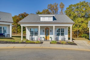 A two-story house with a porch, a front door, and a small attached garage. - Lake Access & Boat Slip: Greenwood Cottage! (Greenwood)
