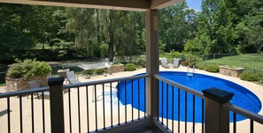 A pool with a surrounding deck, a stone planter, and a view of a wooded area. - 5 Houses, 19 Bd, 14 BA, 16 Acres, Pool, Events! (Friendsville)