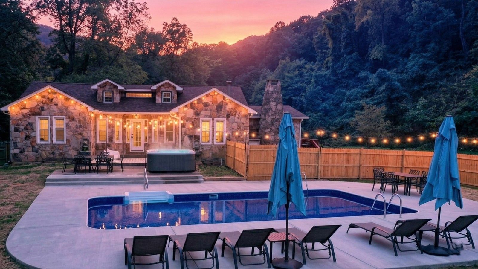 A house with a stone exterior, a swimming pool, and outdoor furniture.