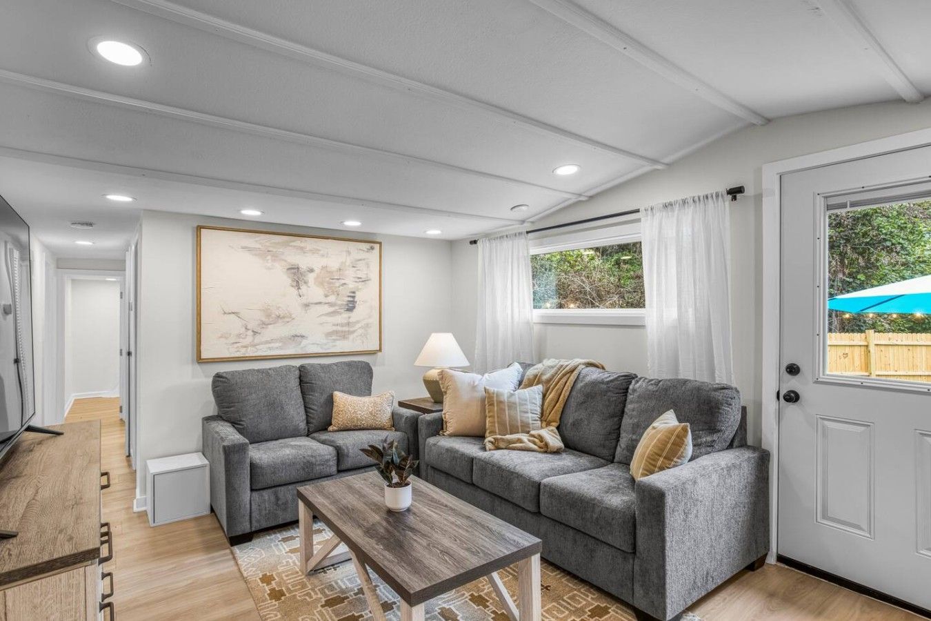 A living room with two grey sofas, a coffee table, and a painting on the wall.