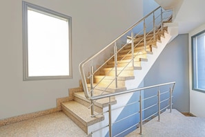 A staircase with metal railings, granite steps, and a window on the landing.
