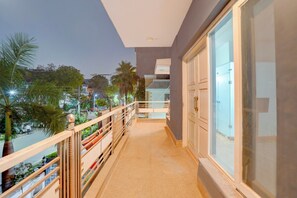 A balcony with a view of a street and palm trees. - Townhouse Sector 49 Sohna Road (Gurugram)