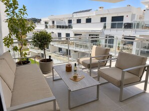 A balcony with a sofa, chairs, a table, and potted plants. - La Casa Eliana 3-bedroom Apartment (AN)