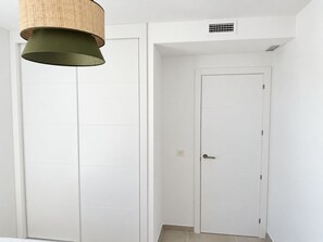 A room with white doors, a hanging lamp, and a vent on the wall. - La Casa Eliana 3-bedroom Apartment (AN)