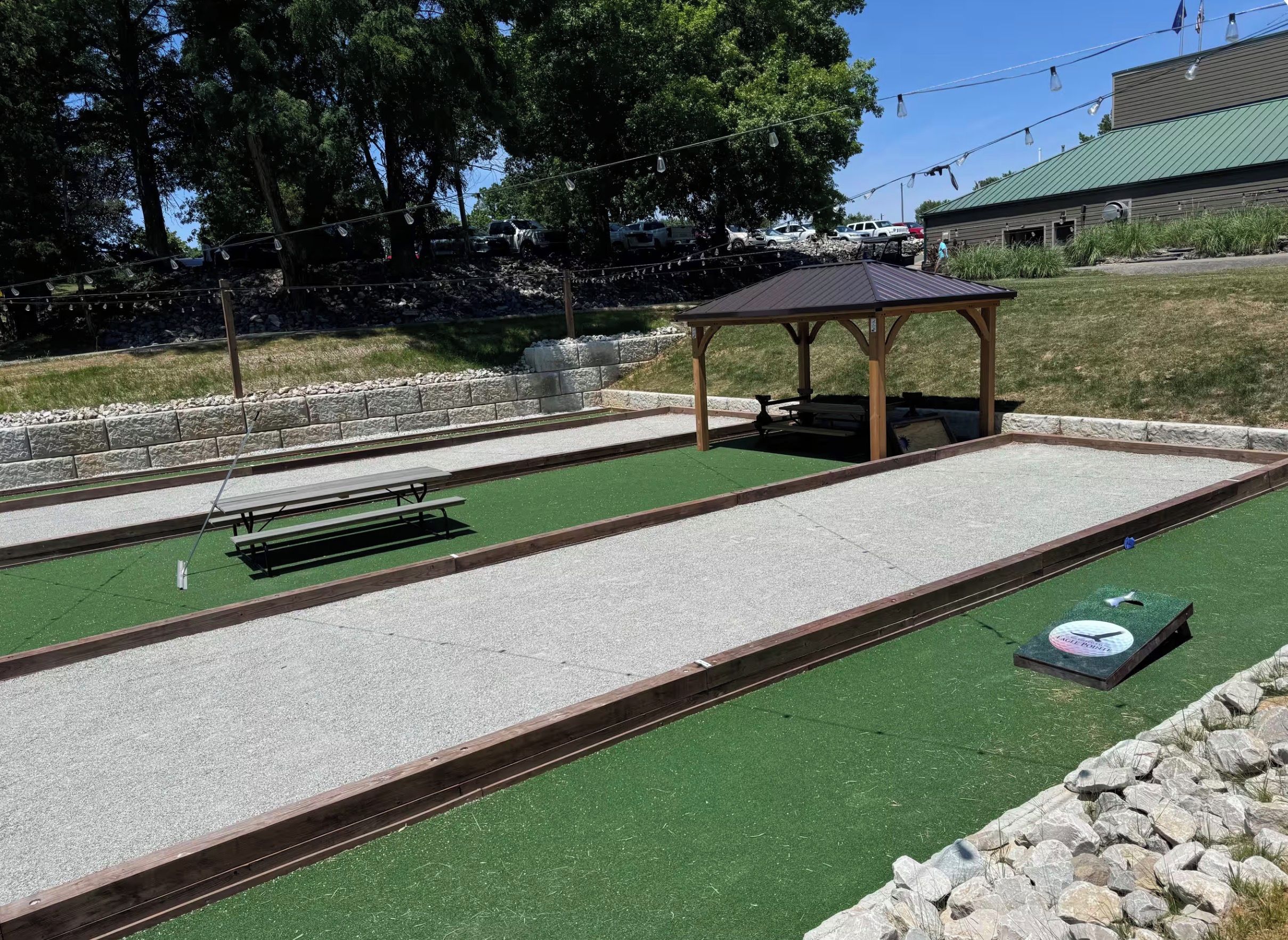 A croquet field with a pavilion, picnic tables, and a lawn.