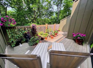 A wooden deck with potted plants and a wooden fence.