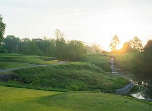 A golf course with a water feature and a path.
