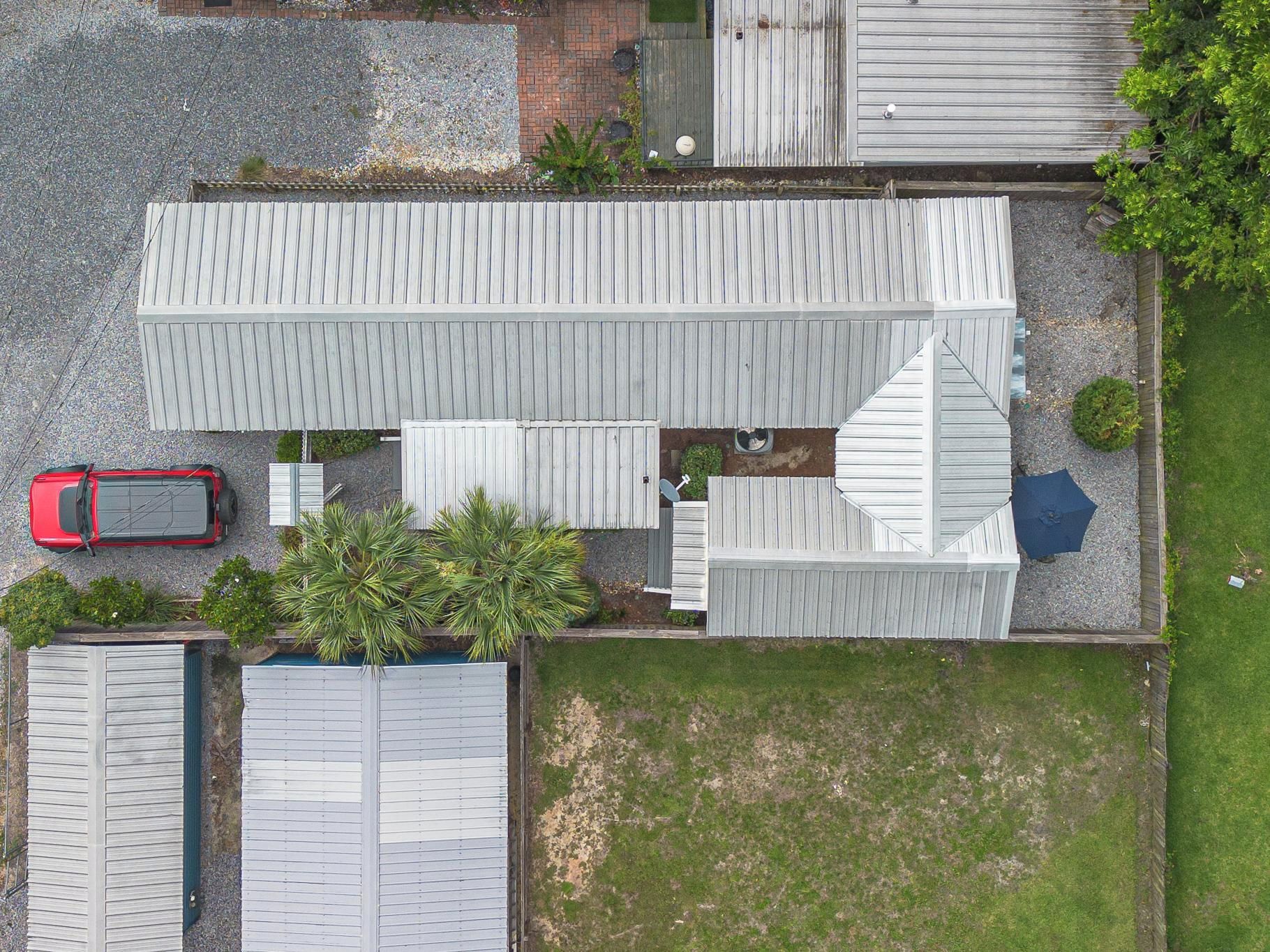 Un quartiere residenziale con diversi edifici, un'auto rossa parcheggiata e un prato.