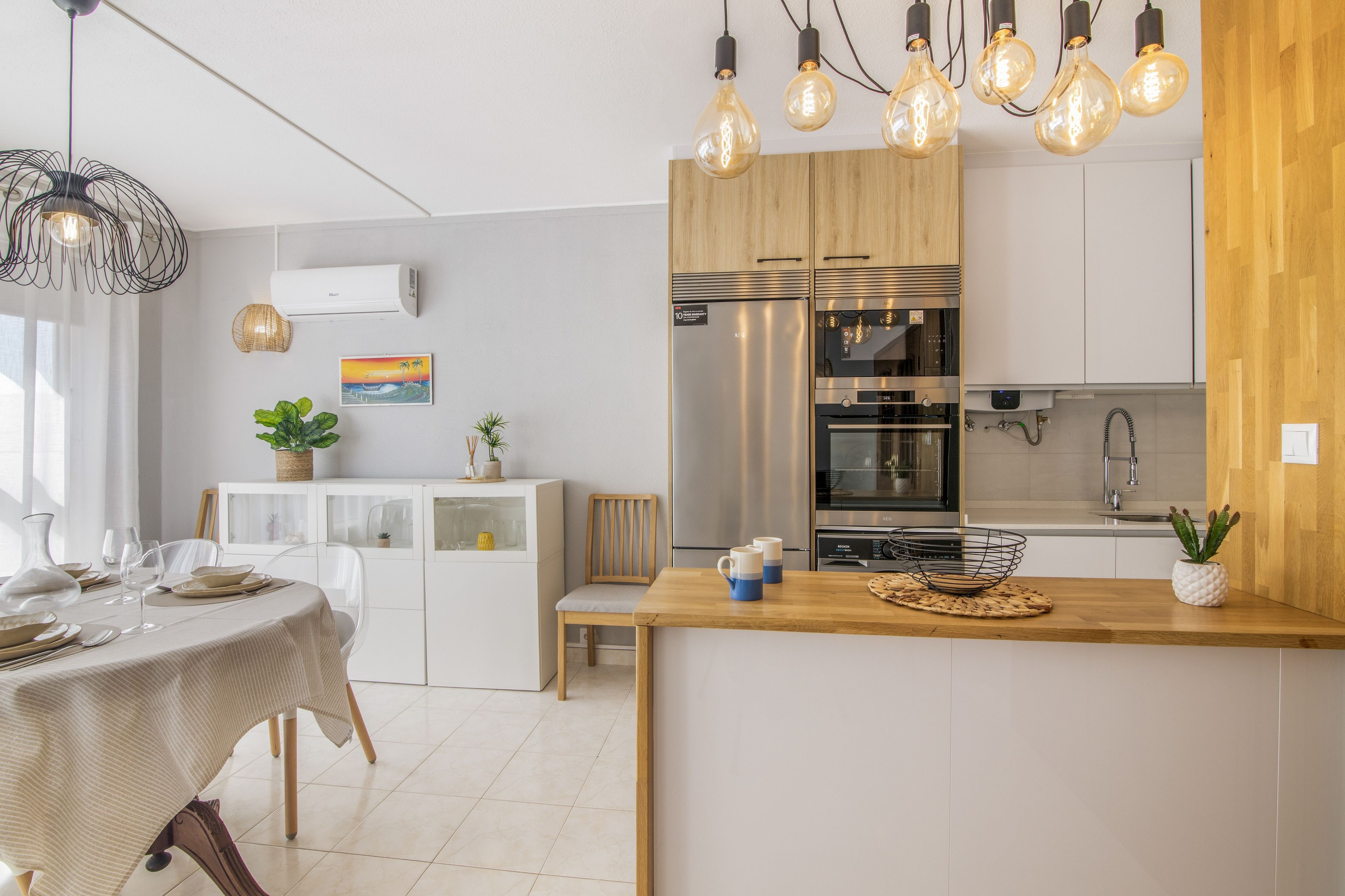 A modern kitchen with a central island, stainless steel appliances, and pendant lighting.