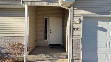 A residential house with a garage, a front door, and a small porch area.