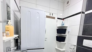 Ein modernes Badezimmer mit einem weißen Waschbecken, einer Toilette und einem Einbauschrank.