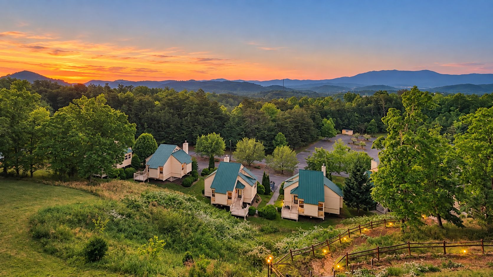 A residential area with multiple houses, each with a green roof, surrounded by lush greenery and hills in the background.