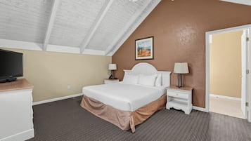 A hotel room with a bed, two bedside tables, a television, and a painting on the wall.