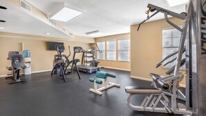 A gym with various exercise equipment, a water dispenser, and a television on the wall. - Sunrise Ridge Resort  (Pigeon Forge)