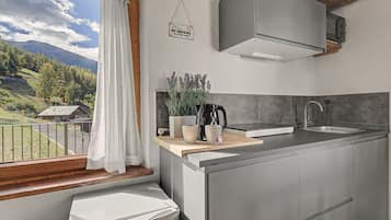 A modern kitchen with a view of a mountainous landscape.