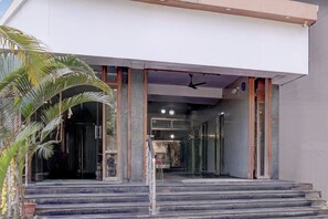 A building entrance with a staircase leading to a covered area. - Super Townhouse Oak Dharwad New Bus (Dharwad)