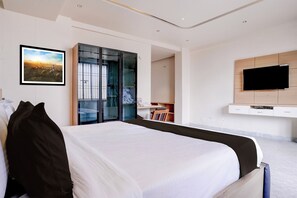 A modern hotel room with a large bed, a television, and a wardrobe. - Super Townhouse Oak Dharwad New Bus (Dharwad)