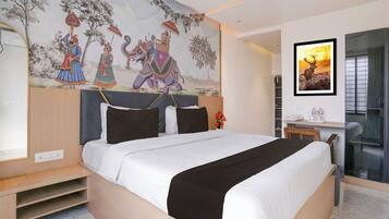 Habitación de hotel moderna con una cama grande, un escritorio y un mural en la pared.