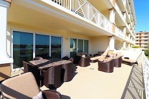 A balcony with wicker furniture, a dining table, and a view of the sea. - Sunny 3-bedroom condo with views in peaceful Indian Shores (Indian Shores)