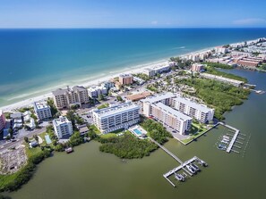 Eine Vogelperspektive auf ein Küstenhotelgebiet mit mehreren Gebäuden, einer Marina und einem Strand.