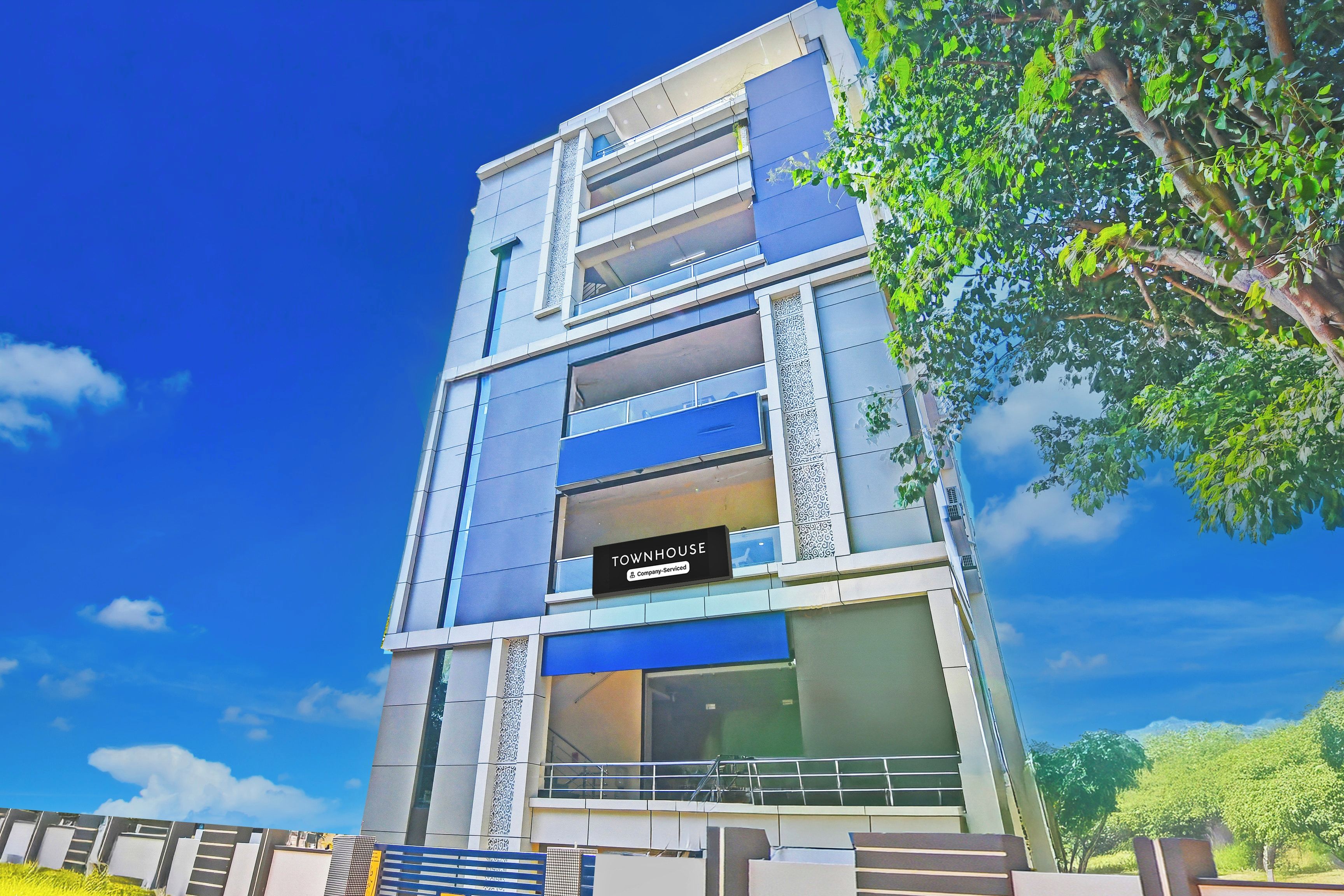 A multi-story building with a sign indicating it is a company-serviced townhouse.