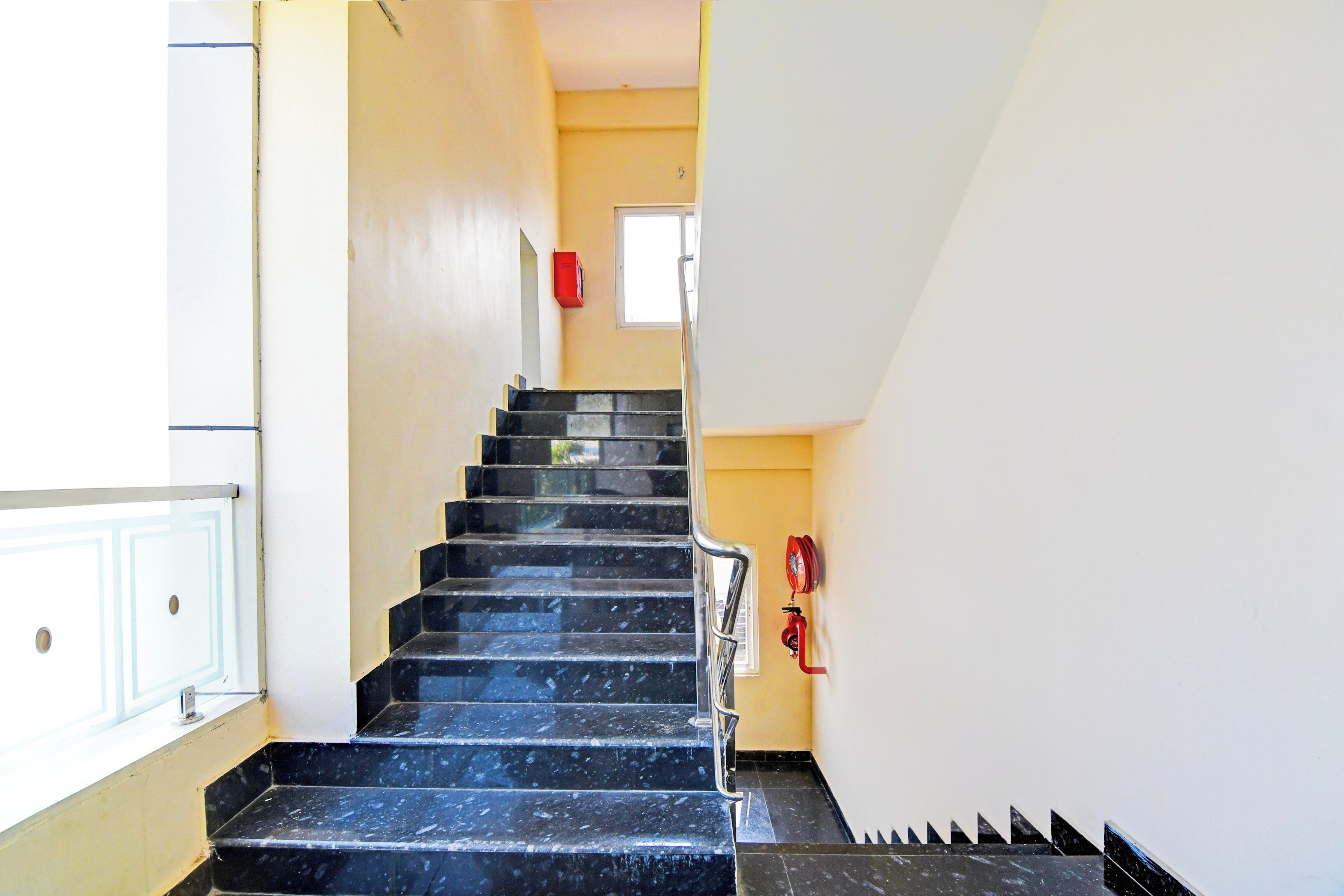 A staircase with black steps leading to a landing.