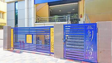 A building entrance with a blue and yellow gate, a staircase, and a fire extinguisher.