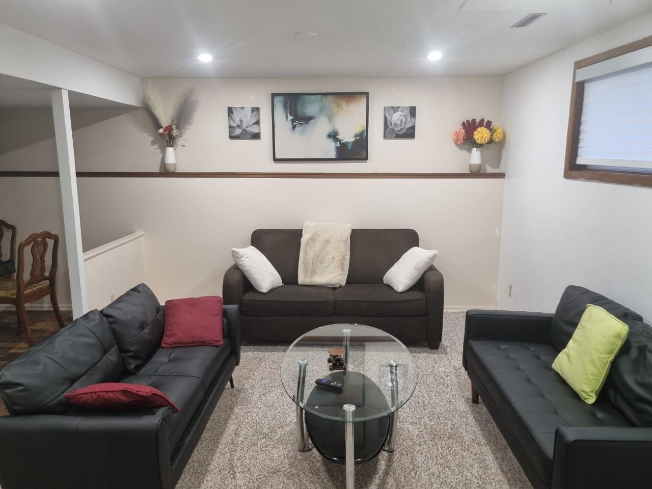 A living room with a sofa set, a coffee table, and wall-mounted artwork.